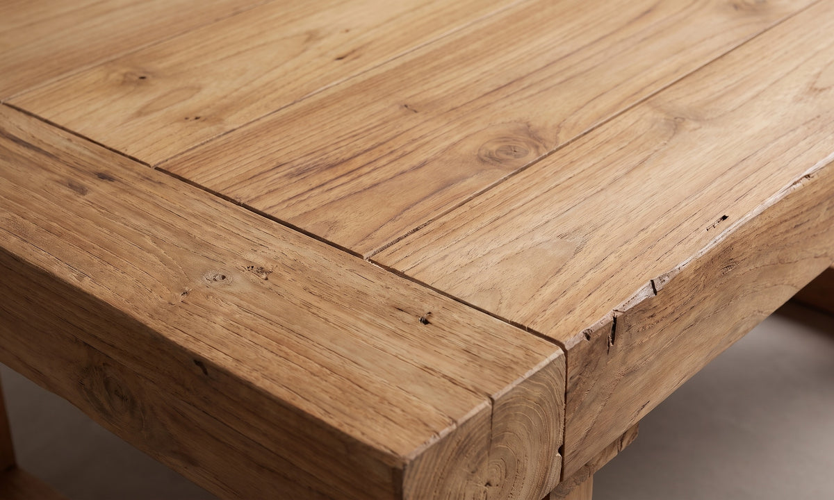 Närbild på bordsskivans hörn i återvunnen teak med plankskarv och ådring